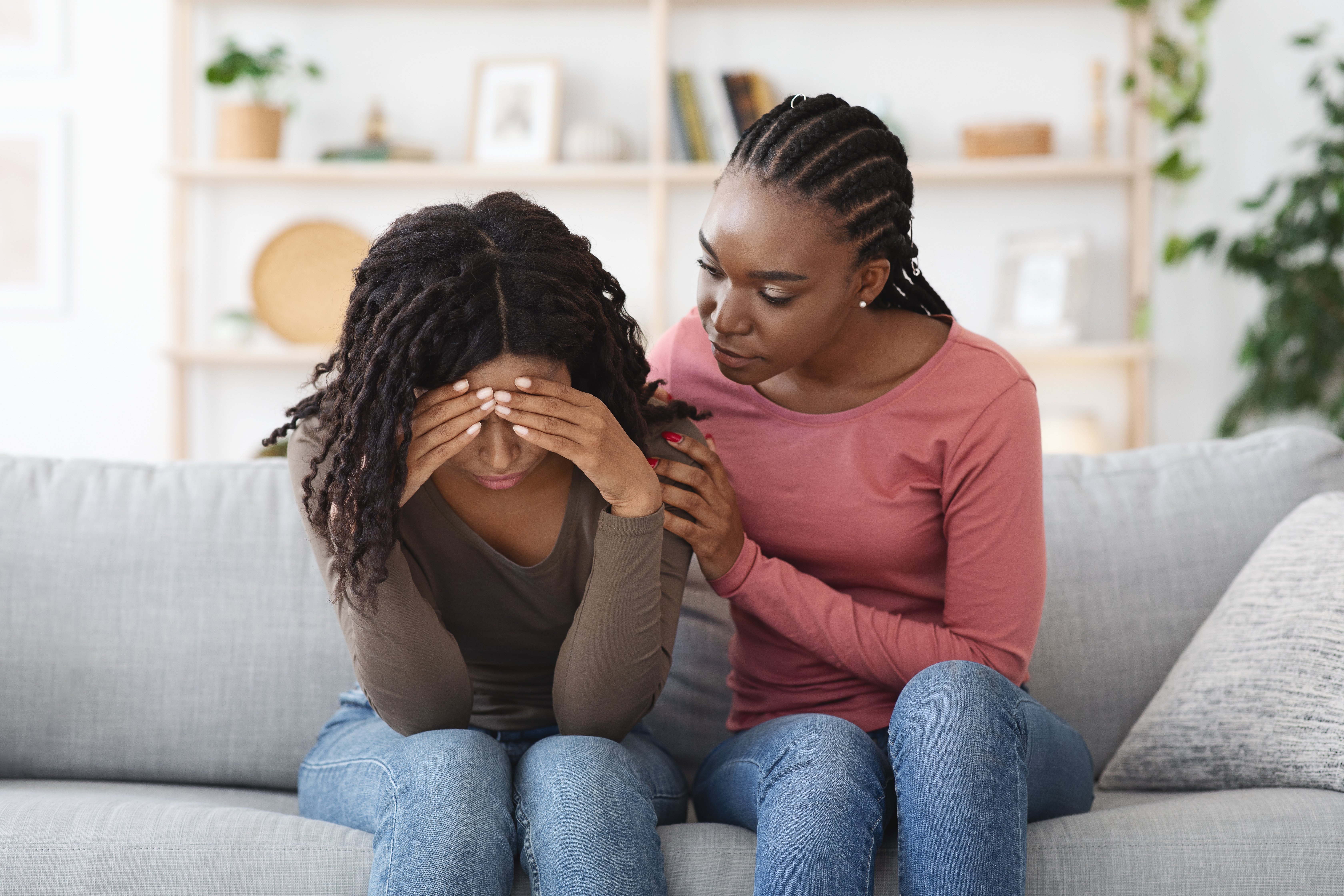 Person comforting a friend on couch