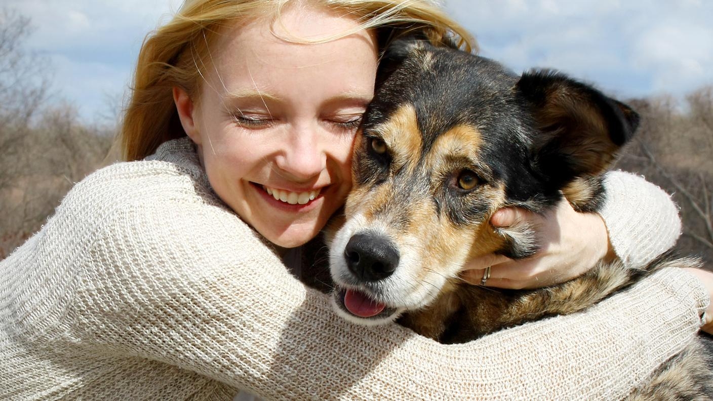 Person cuddling dog