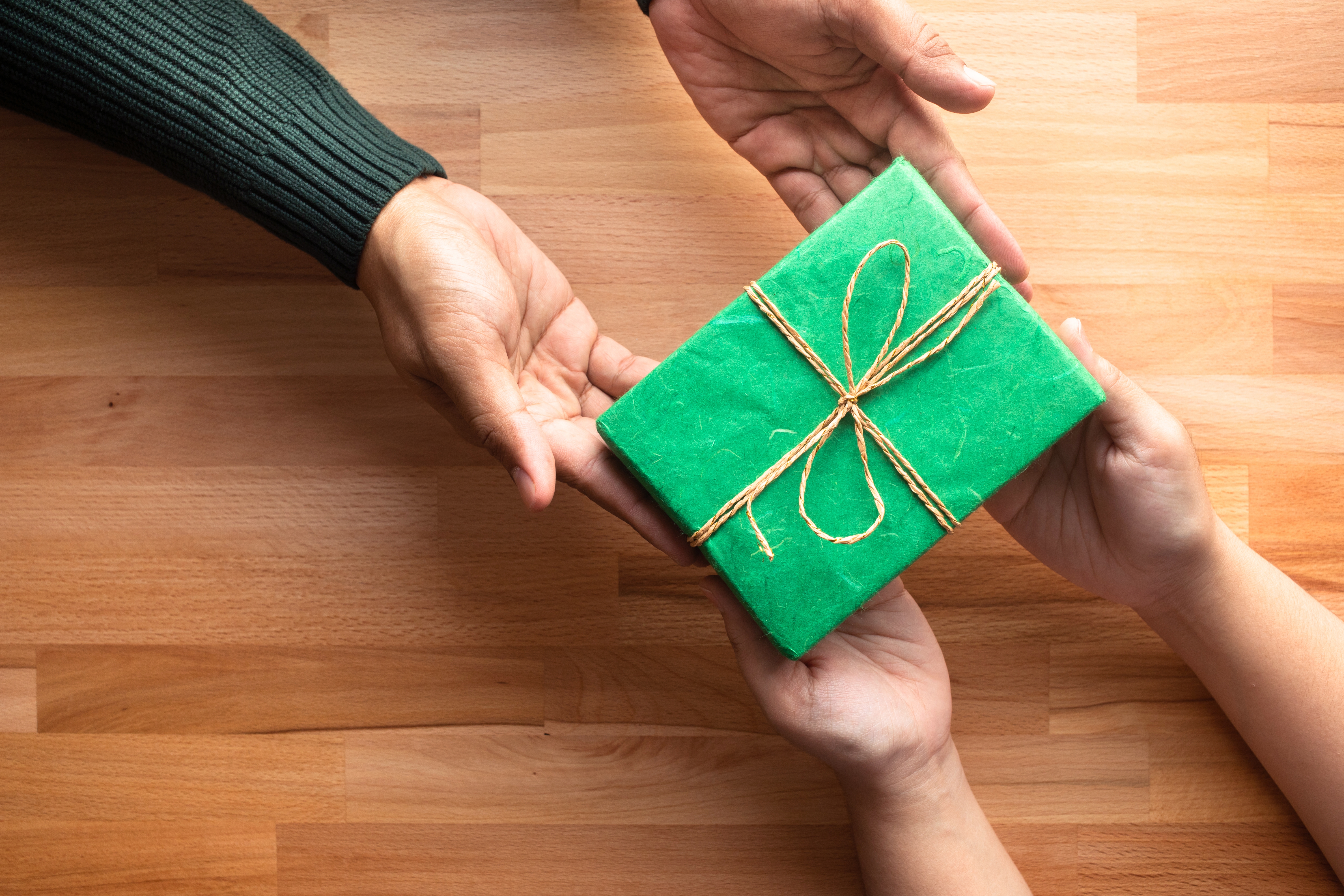 Person handing gift with expectation