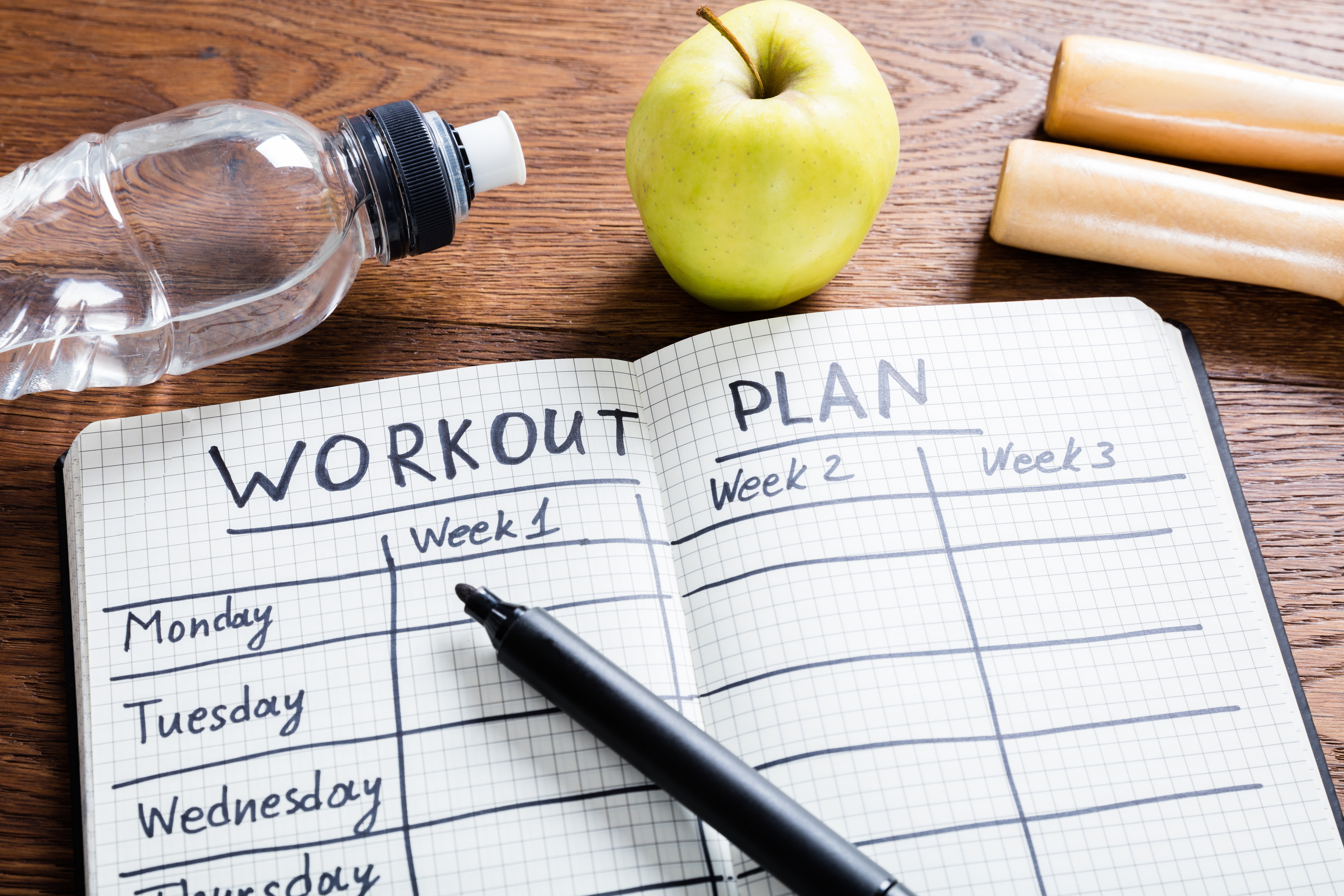 Person planning workout on notepad