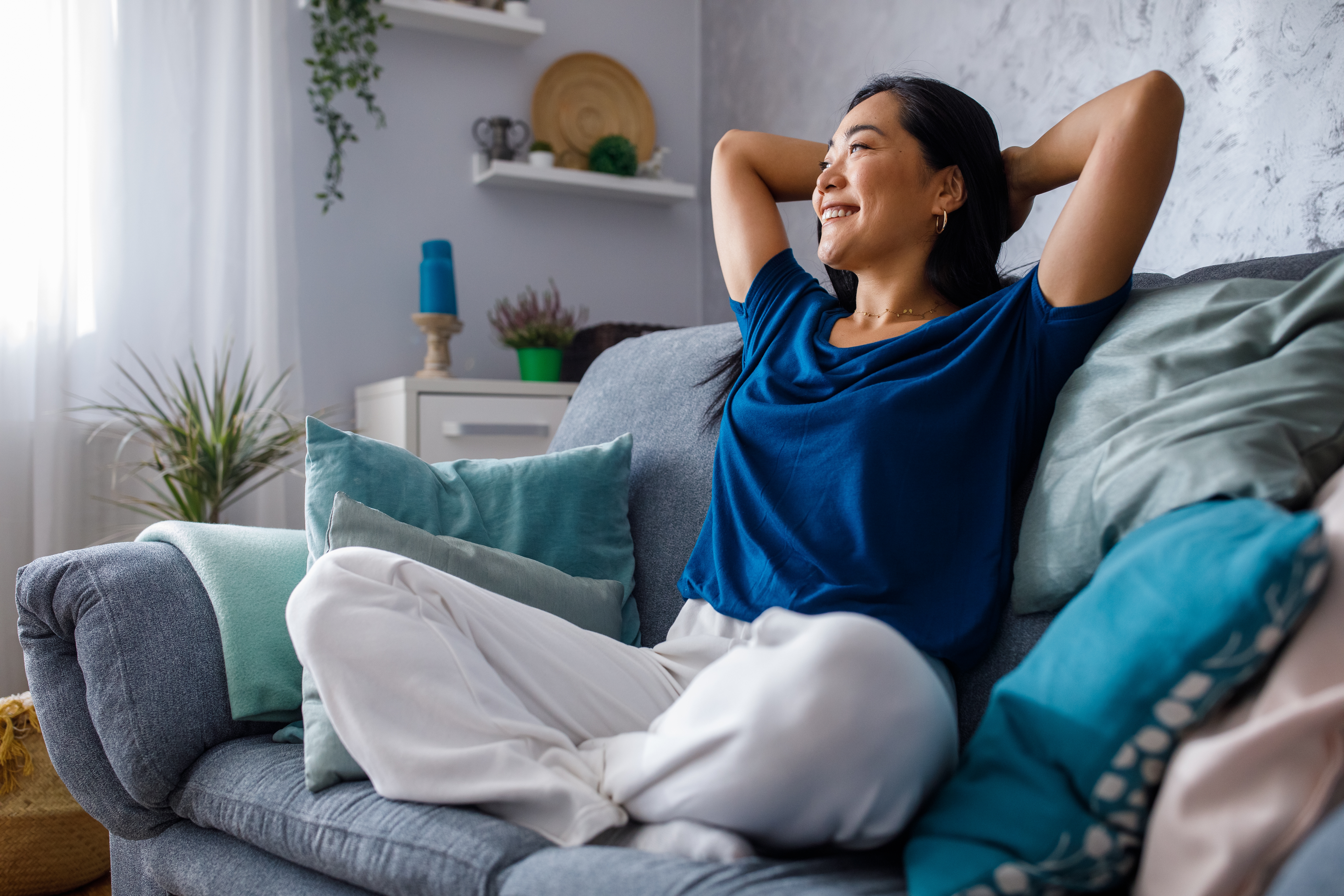 Person resting on couch, cozy self care evening, peaceful bedroom
