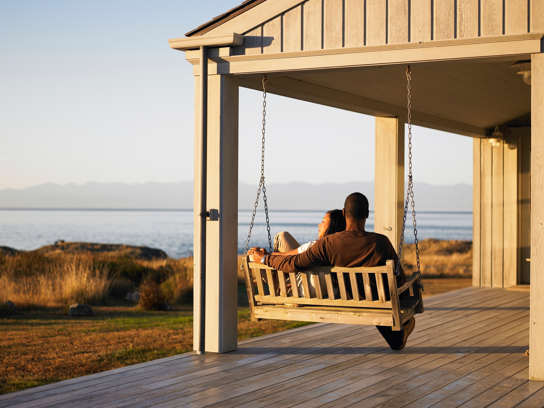 Person sitting on porch at sunset
