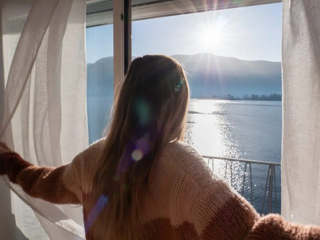 Person taking deep breath at window