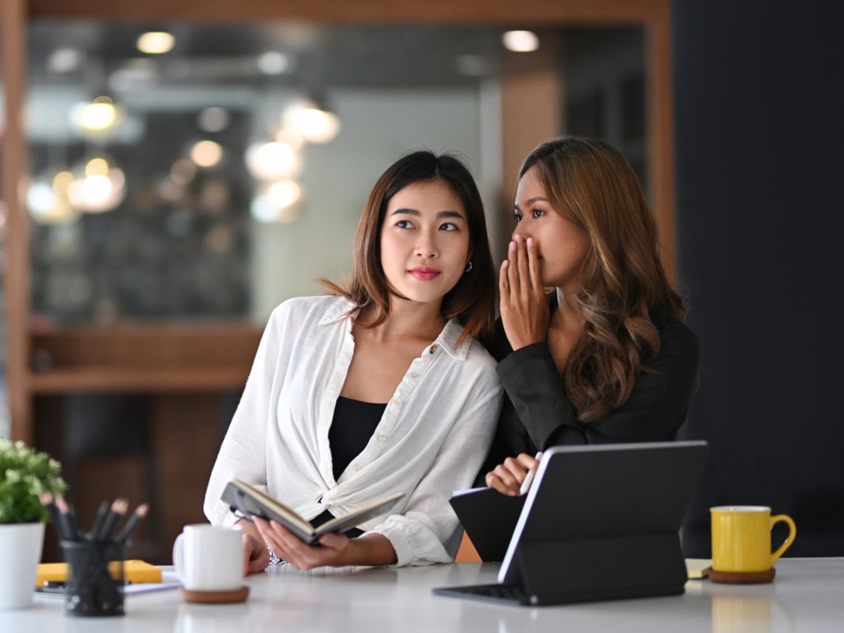 Two coworkers whispering