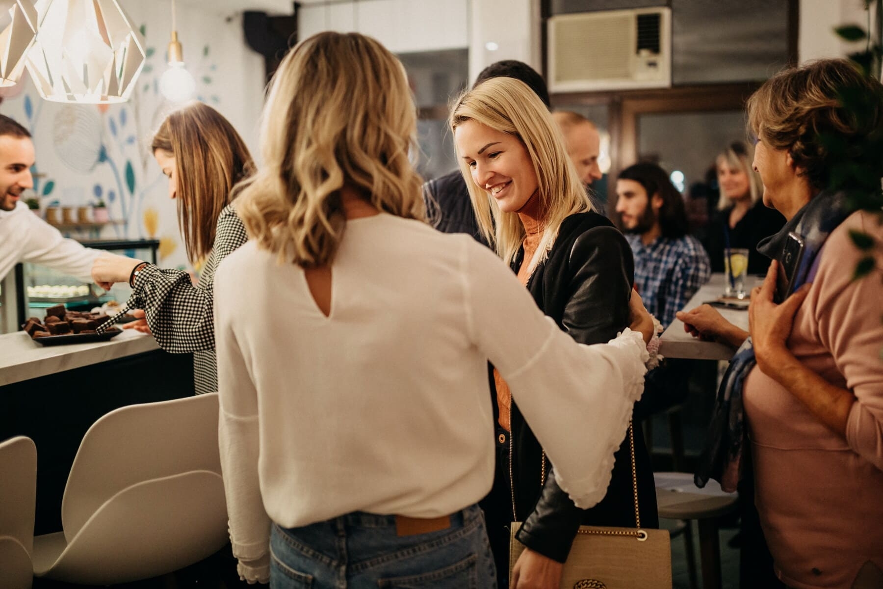 Women complimenting each other, group of women smiling, friends talking at coffee shop